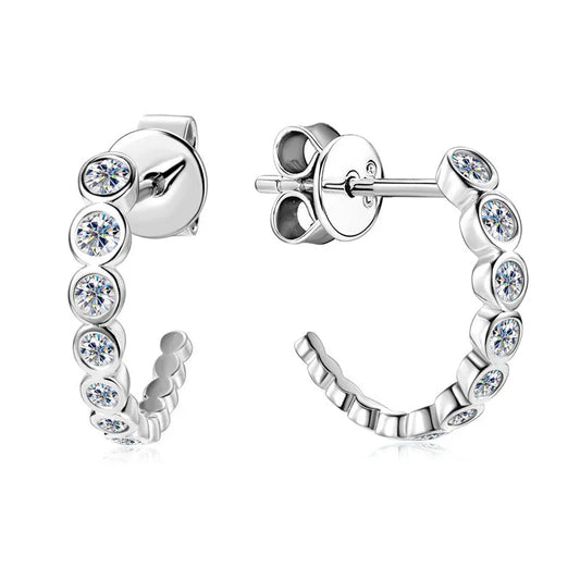 Silver half hoop earrings with round clear crystals in a row on white background
