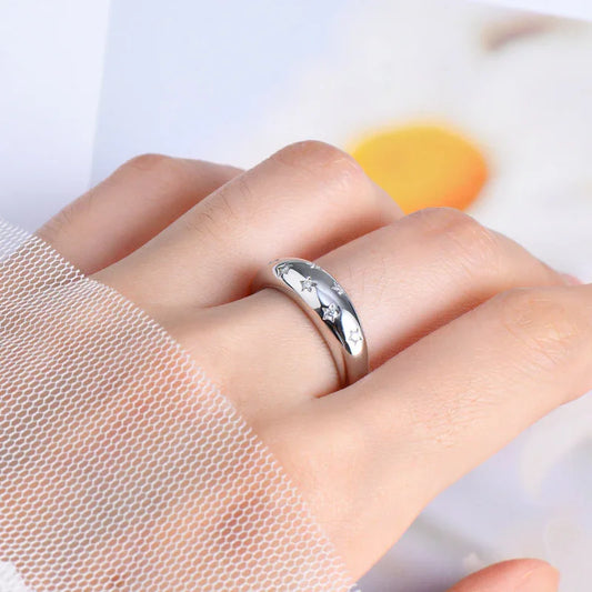 Silver star engraved ring on hand with sheer mesh sleeve