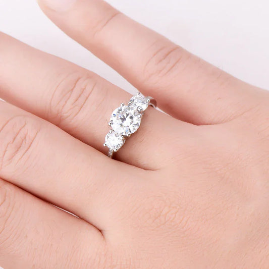 Three-stone diamond engagement ring on hand, silver band, elegant jewelry close-up