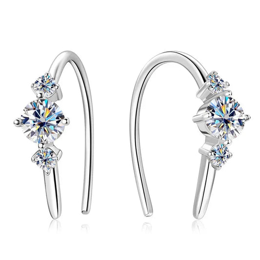 Silver curved earrings with three round cubic zirconia stones on a white background