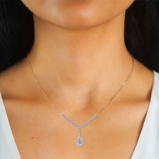 Woman wearing a diamond teardrop pendant necklace on a silver chain