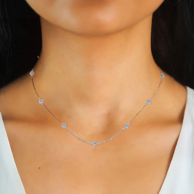 Delicate silver diamond station necklace on woman's neck, minimalist jewelry style