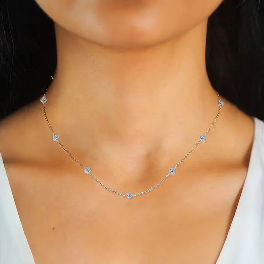 Delicate silver diamond station necklace on woman's neck, minimalist jewelry style